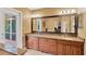 Bathroom with double vanity sinks with granite countertops, and door to outdoor patio at 3913 Little Egret Ct, Lutz, FL 33558
