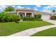 Charming single-story home with lush landscaping, a well-manicured lawn, and a welcoming front entrance at 3913 Little Egret Ct, Lutz, FL 33558
