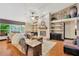Open-concept living room features a brick fireplace, wood floors, and large windows at 3913 Little Egret Ct, Lutz, FL 33558