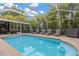 Relaxing in-ground pool surrounded by a screened enclosure with lounge chairs and well-maintained landscaping at 3913 Little Egret Ct, Lutz, FL 33558