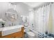 Bathroom featuring a round mirror, farmhouse sink, and a tub with shower at 4769 Stoneview Cir, Oldsmar, FL 34677