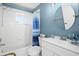 Bathroom featuring a shower-tub combination and a stylish blue vanity at 4769 Stoneview Cir, Oldsmar, FL 34677