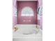Soaking tub in a well-lit bathroom with arched window and modern fixtures at 4769 Stoneview Cir, Oldsmar, FL 34677