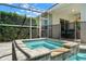 Relaxing hot tub with tiled accents under a screened enclosure, surrounded by lush landscaping at 4769 Stoneview Cir, Oldsmar, FL 34677