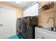 Well-equipped laundry room with modern washer, dryer, sink and ample storage cabinets at 4769 Stoneview Cir, Oldsmar, FL 34677