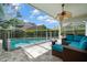 Covered outdoor pool area with stylish seating and a fire pit perfect for entertaining at 4769 Stoneview Cir, Oldsmar, FL 34677