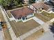 Aerial view of a single-story home with a brown roof, a well-maintained lawn, and a fenced yard at 4816 E 99Th Ave, Tampa, FL 33617