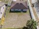 Back aerial view displays the home, sliding glass doors, fenced yard, and mature trees at 4816 E 99Th Ave, Tampa, FL 33617