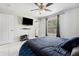 Bedroom with modern ceiling fan, mounted TV, and window view at 4816 E 99Th Ave, Tampa, FL 33617