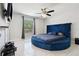 Bright bedroom features a round, upholstered bed, ceiling fan and natural light at 4816 E 99Th Ave, Tampa, FL 33617