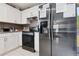 Bright kitchen featuring stainless steel refrigerator and modern appliances with white cabinets at 4816 E 99Th Ave, Tampa, FL 33617