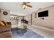 Cozy living room with tile flooring, a ceiling fan, and an adjacent kitchen area at 4816 E 99Th Ave, Tampa, FL 33617