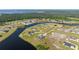 Aerial view of a tranquil lake community with well-maintained homes and lots of trees at 5325 San Remo Cir, Wimauma, FL 33598