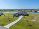 Aerial view of a stunning home with lush landscaping, long driveway, and lake views at 5325 San Remo Cir, Wimauma, FL 33598