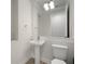 A well-lit bathroom features a pedestal sink, modern lighting, and a toilet at 5325 San Remo Cir, Wimauma, FL 33598