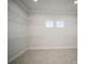 Spacious walk-in closet featuring ample shelving and two arched windows at 5325 San Remo Cir, Wimauma, FL 33598