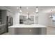 Modern kitchen with stainless steel appliances, gray cabinets, and a large center island at 5325 San Remo Cir, Wimauma, FL 33598