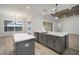 Modern kitchen with an island, gray cabinets, stainless steel appliances, and recessed lighting at 5325 San Remo Cir, Wimauma, FL 33598