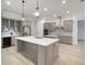 Modern kitchen with an island, stainless steel appliances, gray cabinets and a beverage refrigerator at 5325 San Remo Cir, Wimauma, FL 33598