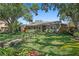 Charming single-story home featuring a lush front lawn, vibrant landscaping, and a welcoming walkway leading to the front door at 6213 10Th S Ave, Gulfport, FL 33707