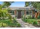 Charming single-story home with well-kept lawn, garden beds, and a stone walkway leading to the decorative front door at 6213 10Th S Ave, Gulfport, FL 33707