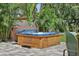 Inviting wooden hot tub on a paved patio surrounded by tropical foliage at 6213 10Th S Ave, Gulfport, FL 33707