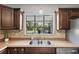 Close-up of kitchen featuring tile backsplash, stainless steel sink, and wood cabinets at 6213 10Th S Ave, Gulfport, FL 33707