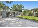 Wide view of the property showcasing the spacious driveway, backyard, and lush landscaping at 6213 10Th S Ave, Gulfport, FL 33707