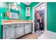 Bathroom boasts seafoam green walls, a decorative cabinet, tile countertops, and walk-in closet access at 6238 92Nd N Pl # 3201, Pinellas Park, FL 33782