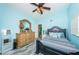 This bedroom offers blue walls, a ceiling fan, gray wood floors, and access to the en-suite bathroom at 6238 92Nd N Pl # 3201, Pinellas Park, FL 33782
