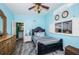 Bright bedroom boasts gray wood floors, ceiling fan, blue walls, and updated bathroom access at 6238 92Nd N Pl # 3201, Pinellas Park, FL 33782
