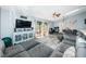 Spacious living room with gray wood floors, a plush sectional sofa, and sliding door to the outside deck at 6238 92Nd N Pl # 3201, Pinellas Park, FL 33782