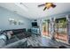 Bright living room featuring a large sectional couch, wood-look floors, and access to the outdoor balcony at 6238 92Nd N Pl # 3201, Pinellas Park, FL 33782