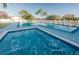 Community pool and hot tub surrounded by lounge chairs and trees at 6238 92Nd N Pl # 3201, Pinellas Park, FL 33782
