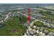 An aerial view uses a red arrow to identify homes within a community surrounded by nature at 6307 Salt Creek Ave, Apollo Beach, FL 33572