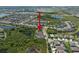 An aerial view uses a red arrow to point to homes in a community with attractive landscaping and natural pond areas at 6307 Salt Creek Ave, Apollo Beach, FL 33572