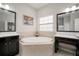 This bathroom features a soaking tub, dual sinks, and granite countertops at 6307 Salt Creek Ave, Apollo Beach, FL 33572