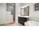A shower stall with gray tiled walls and glass enclosure in this bathroom at 6307 Salt Creek Ave, Apollo Beach, FL 33572