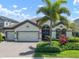 Charming single-Gathering home with a three-car garage, paver driveway, and mature landscaping with a palm tree at 6307 Salt Creek Ave, Apollo Beach, FL 33572