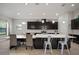 Bright kitchen featuring a large island, white countertops, dark cabinets and a dining area at 6307 Salt Creek Ave, Apollo Beach, FL 33572