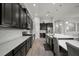 Modern kitchen boasting stainless steel appliances, dark cabinetry, and a spacious island at 6307 Salt Creek Ave, Apollo Beach, FL 33572