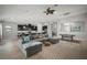 Open-concept living room with gray sectional, wood floors, and adjacent kitchen and dining areas at 6307 Salt Creek Ave, Apollo Beach, FL 33572