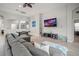 Bright living room with gray sectional, decorative ceiling fan, and view into the dining area at 6307 Salt Creek Ave, Apollo Beach, FL 33572
