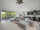 Spacious living room featuring a large gray sectional sofa and sliding glass doors to the outside patio at 6307 Salt Creek Ave, Apollo Beach, FL 33572
