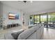 Cozy living room with a large gray sectional, tiled floors, and a sliding glass door at 6307 Salt Creek Ave, Apollo Beach, FL 33572