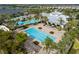 Aerial view of a large community pool, including sun loungers, palm trees, and lush landscaping at 6307 Salt Creek Ave, Apollo Beach, FL 33572