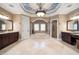 An elegant bathroom featuring a large tub, a decorative ceiling, marble floors, and dark wood vanities at 6408 Bright Bay Ct, Apollo Beach, FL 33572