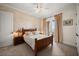 A well-lit bedroom with neutral tones featuring a decorative accent wall, ceiling fan and balcony access at 6408 Bright Bay Ct, Apollo Beach, FL 33572