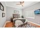 Comfortable bedroom featuring hardwood floors, ceiling fan, and a cozy queen-sized bed at 6461 Rubia Cir, Apollo Beach, FL 33572