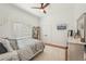 Bright bedroom featuring hardwood floors, ceiling fan, and a cozy queen-sized bed at 6461 Rubia Cir, Apollo Beach, FL 33572